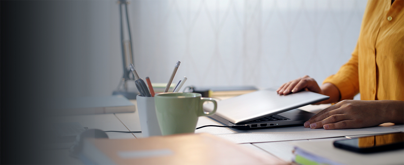 desk with cups, and hands closing laptop