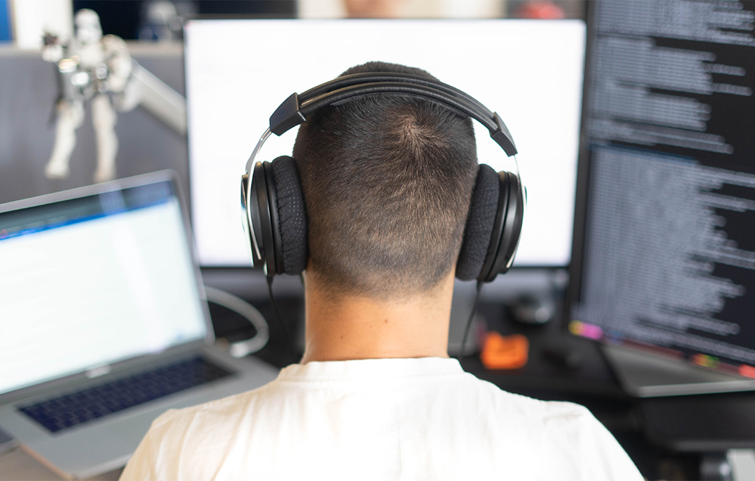 workday employee at desk with headphones on working