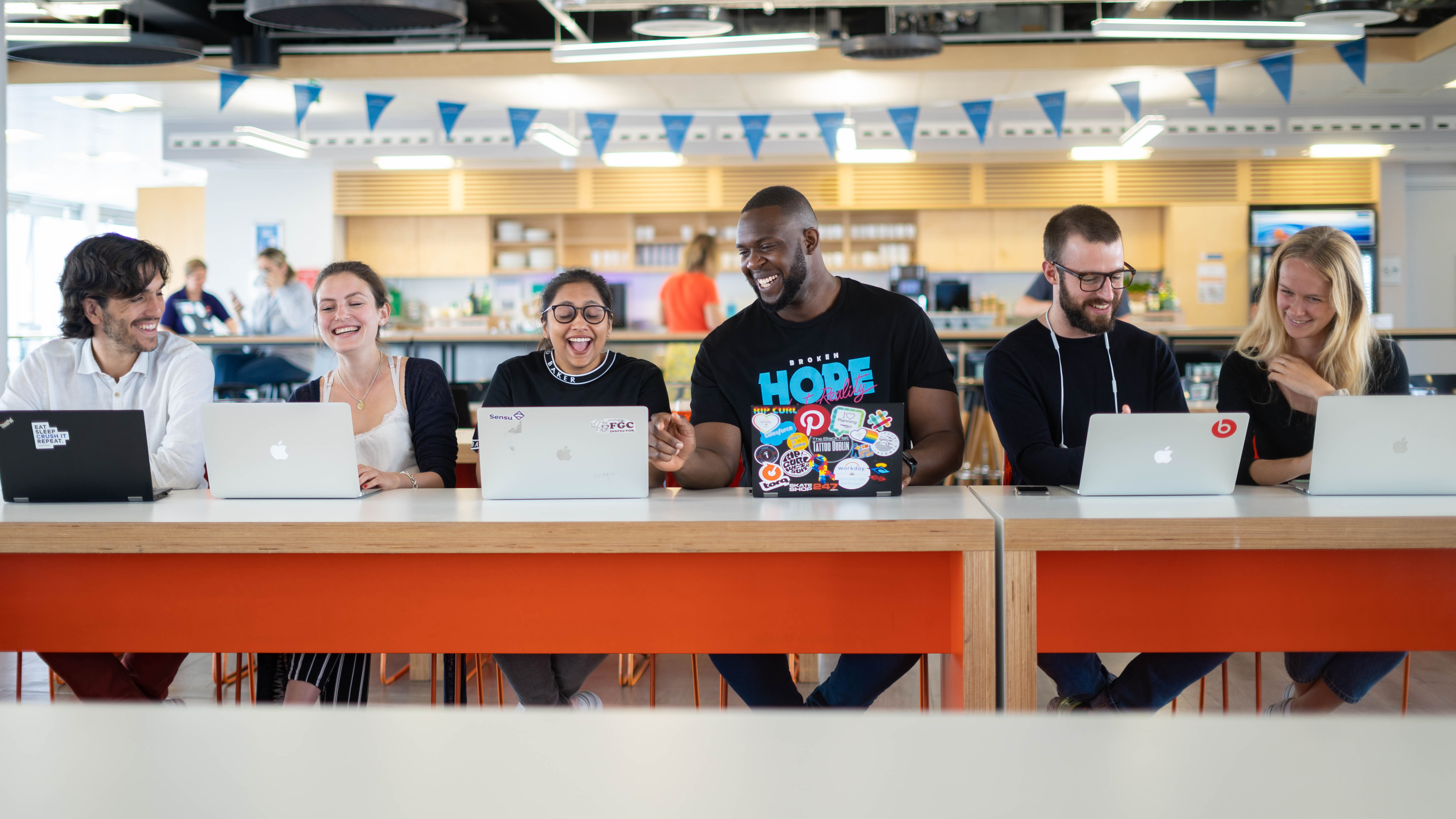 workday employees sitting at table with laptops